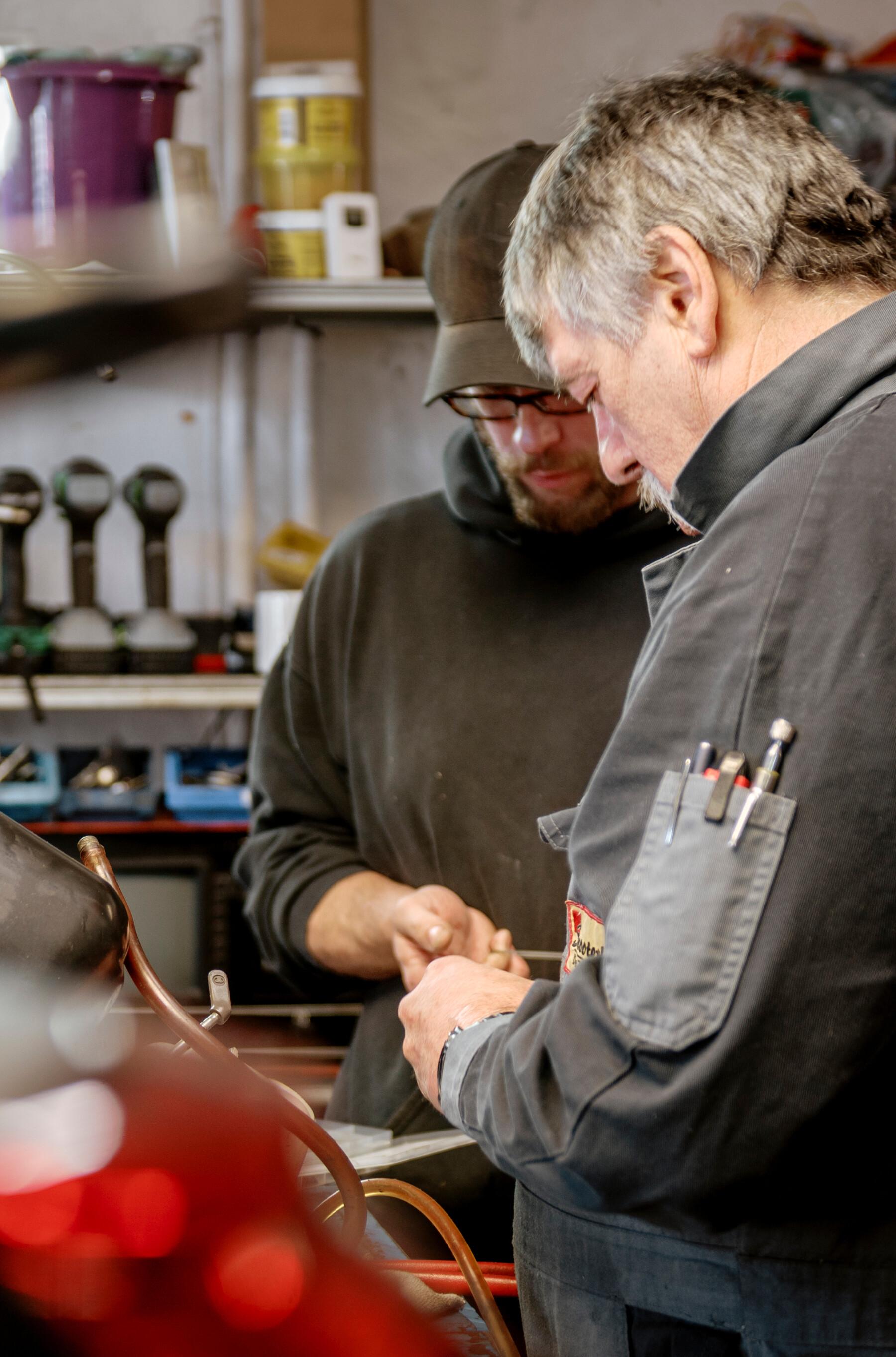 Zwei Mechaniker von Scooterland bei der Arbeit in der Werkstatt